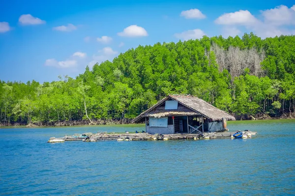 Buiten beeld van oude en beschadigde huis drijvend in de rivier dicht bij de mangroven in een gorgeopus blauw asky in Krabi provincie, Zuid Thailand — Stockfoto