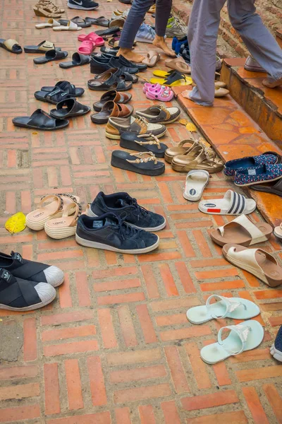 AYUTTHAYA, TAILANDIA, 08 DE FEBRERO DE 2018: Primer plano de la vista al aire libre de muchos zapatos surtidos en el suelo durante una ceremonia y tiempo de oración cerca de Wat Mahathat. Parque histórico de Ayutthaya —  Fotos de Stock