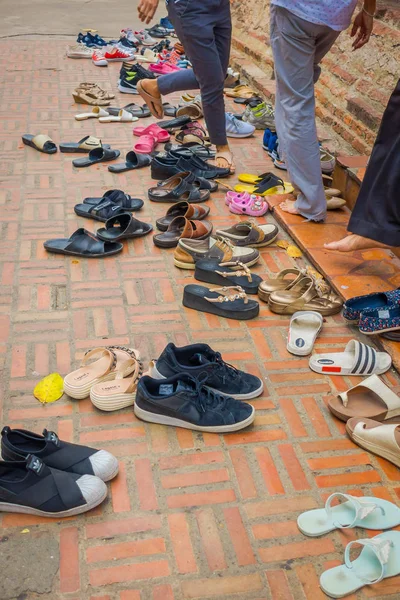 AYUTTHAYA, TAILANDIA, 08 DE FEBRERO DE 2018: Primer plano de la vista al aire libre de muchos zapatos surtidos en el suelo durante una ceremonia y tiempo de oración cerca de Wat Mahathat. Parque histórico de Ayutthaya —  Fotos de Stock