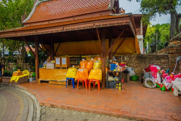 Αγιουτχάγια, Ταϊλάνδη, Φεβρουάριος 08, 2018: Εξωτερική άποψη κίτρινο υφασμάτων μέσα σε πλαστικές σακούλες κάτω από ένα ξύλινο αγορά κτήριο στο ιστορικό Πάρκο Ayutthaya, Ταϊλάνδη — Φωτογραφία Αρχείου