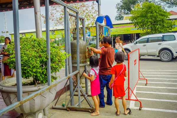 AYUTTHAYA, TAILANDIA, 08 DE FEBRERO DE 2018: Vista exterior de personas no identificadas tocando la campana sagrada dentro de un templo en Ayutthaya — Foto de Stock