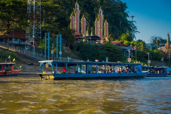 Schitterend uitzicht op een groep toeristen in toeristische boten de gouden budha attractiepark gouden driehoek Laos met sommige gebouw in de rivieroever — Stockfoto