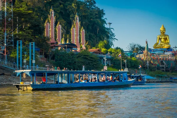 Schitterend uitzicht op een groep toeristen in toeristische boten de gouden budha attractiepark gouden driehoek Laos met sommige gebouw in de rivieroever — Stockfoto