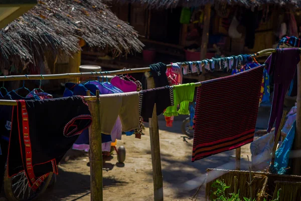 Outdoor view of clothes drying in the sun Long Neck tribe, Kayan Lahwi, with taditional houses around — Stock Photo, Image