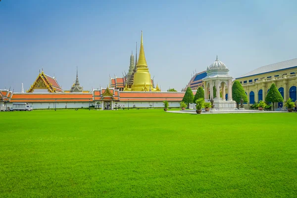 Belle vue extérieure de l'herbe verte avec un Wat Pho ou Wat Phra Chetuphon dans l'horizont, Wat signifie temple en thaï. Le temple est l'un des sites touristiques les plus célèbres de Bangkoks en Thaïlande — Photo
