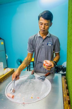 Ao Nang, Tayland - 19 Şubat 2018: dostum tavada kızartılmış dondurma rulo, donma pan, çalışan kimliği belirsiz erkeğin dondurma tatlı yaptı. Kızarmış dondurma makinesi ile çelik soğutulmuş pan
