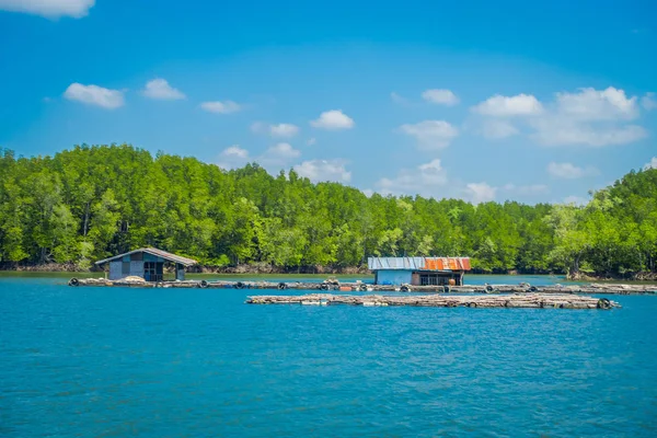 Vista ao ar livre de casa velha e danificada flutuando no rio perto dos manguezais em um gorgeopus azul asky na província de Krabi, sul da Tailândia — Fotografia de Stock