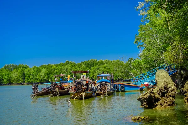AO NANG, TAILÂNDIA - FEVEREIRO 19, 2018: Barcos de pesca de cauda longa na margem do rio perto da estrutura metálica no cais localizado no rio na província de Krabi, sul da Tailândia — Fotografia de Stock