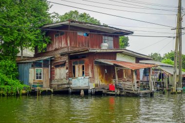 Zavallı ev nehir Chao Phraya Nehri üzerinde kablo hatları ile yüzer. Tayland, Bangkok