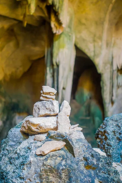 Gros plan de la concentration sélective de petites roches l'une sur l'autre en équilibre à l'entrée de l'ancienne grotte Tham Pee Hua Toe ou Grotte Fantôme à grosse tête dans la province de Krabi, Thaïlande — Photo