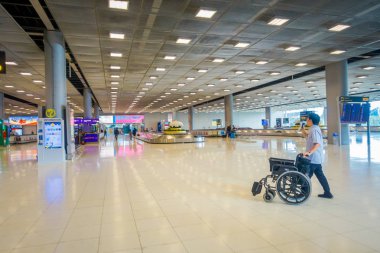 Bangkok, Tayland - 08 Şubat 2018: İç kimliği belirsiz adam bir salonda Don Mueang Uluslararası Havalimanı, Terminal 2 yürüyüş bir tekerlekli sandalye ile bütçe Havayolları'nın Tayland görülmektedir