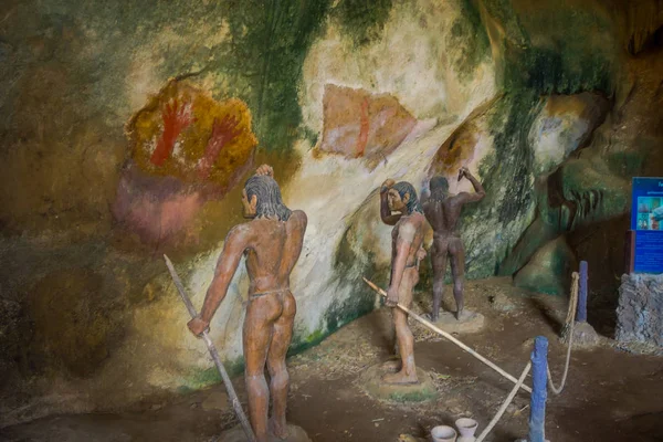 Beautiful indoor view of stoned caveman with spear in their hands inside of ancient cave Khao khanabnam in Krabi province, Thailand