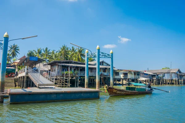 AO NANG, TAILANDIA - 19 DE FEBRERO DE 2018: Hermosa vista al aire libre del barco de pesca de cola larga cerca de edificios antiguos ubicados en el río en granjas de peces en el muelle de la provincia de Krabi, al sur de Tailandia — Foto de Stock