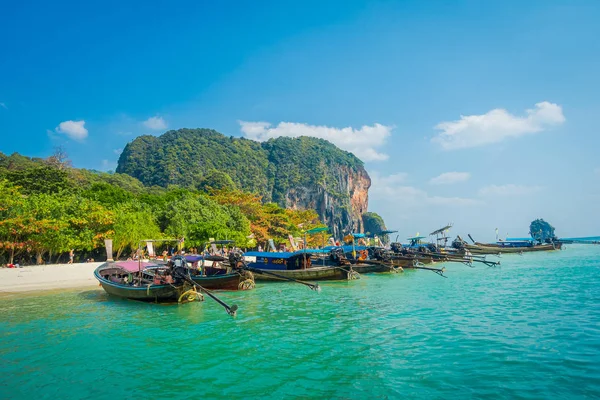 PHRA NANG, THAILAND - 09 февраля 2018 года: Прекрасный вид на длинную хвостовую лодку подряд в Таиланде, стоящую на острове Пхра Нанг в великолепный солнечный день и бирюзовую воду — стоковое фото