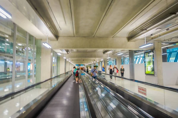 BANGKOK, TAILANDIA - 01 DE FEBRERO DE 2018: Vista interior de personas borrosas no identificadas caminando en una escalera plana eléctrica en el Hall de Llegada en el Aeropuerto Internacional Don Mueang — Foto de Stock
