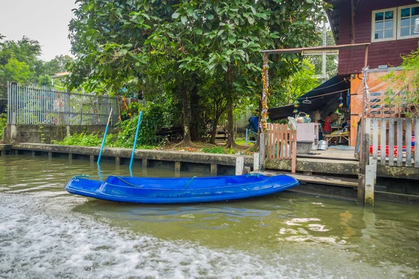 Vista esterna della piccola barca di plastica blu sul lungofiume al canale Yai o Khlong Bang Luang in Thailandia — Foto Stock