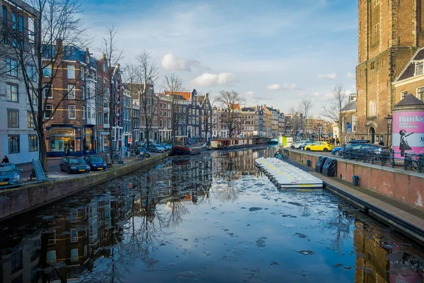 Амстердам, Нідерланди, 10 березня 2018 роки: Чудовий вид на деякі автомобілі, припарковані на вулиці недалеко від багатьох човна в каналах Амстердама, є столицею і чисельністю місто Нідерландів — стокове фото