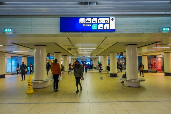 AMSTERDAM, PAÍSES BAJOS - 11 DE MARZO DE 2017: Vista interior de personas no identificadas caminando dentro de un edificio de Ámsterdam en la terminal de salida del transporte público en el municipio de Haarlemmermeer — Foto de Stock