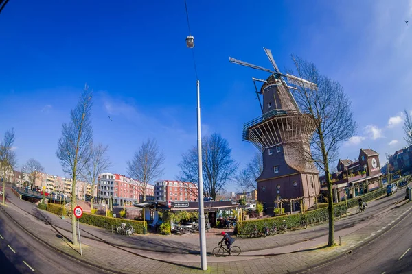 AMSTERDAM, PAESI BASSI, 10 MARZO 2018: Splendida vista esterna di persone non identificate che camminano vicino al mulino a vento De Gooyer - il mulino in legno più alto dei Paesi Bassi Amsterdam — Foto Stock