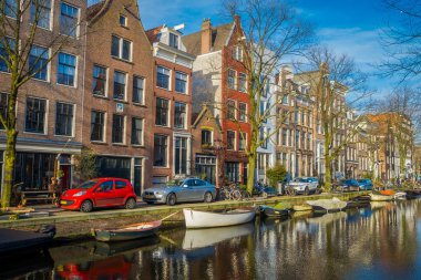Amsterdam, Hollanda, Mart, 10 2018: Açık yakın bir teknelerle Amsterdam kanalları sokakta park edilmiş araba görünümüdür Hollanda'nın başkenti ve en kalabalık