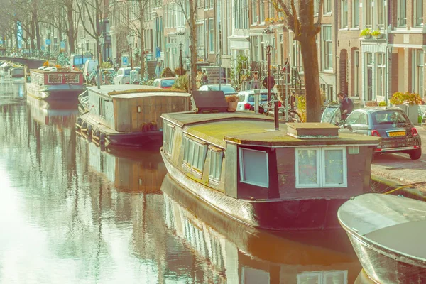 Amsterdam, Niederlande, märz, 10 2018: aussenansicht schwimmender hausboote und wohnhäuser auf einem kanal in der stadt amsterdam — Stockfoto