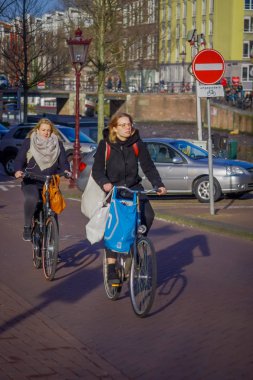 Amsterdam, Hollanda, Mart, 10 2018: Amsterdam'ın tarihi bölümünde bisiklet sürme tanımlanamayan kişi