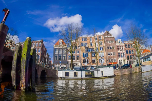 AMSTERDAM, PAESI BASSI, 10 marzo 2018: Vista esterna di case galleggianti e condomini su un canale nella città di Amsterdam — Foto Stock
