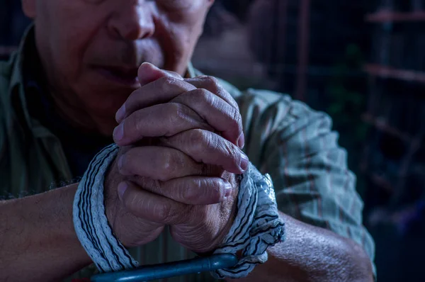 Κοντινό πλάνο του ανθρώπου τα χέρια τυλιγμένα με σχοινί γύρω από τους καρπούς σε αιχμαλωσία, θύματος, κακοποίηση, Δούλος της εργασίας, σεβασμό για τα ανθρώπινα δικαιώματα και εκμετάλλευση έννοια που απομονώνονται σε θολή φόντο — Φωτογραφία Αρχείου