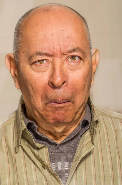 Portrait of a happy mature man doing funny faces and posing for camera in a blurred background