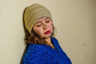 Kaldırıma mavi kapüşonlu soğuk sonbahar havalarda sokakta evsiz kadın portresi