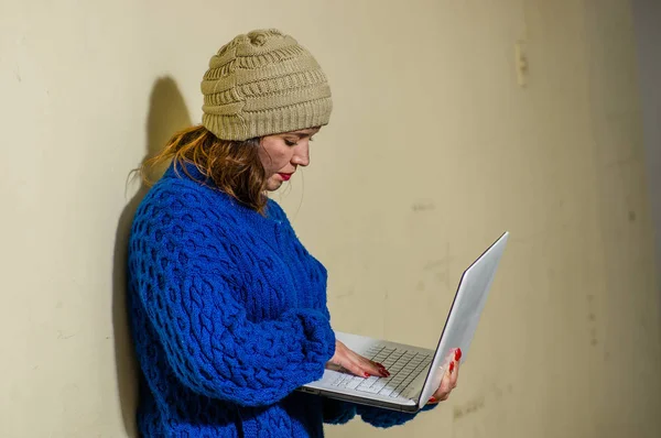 Zewnętrzny widok bezdomna kobieta na ulicy w niskich temperaturach jesień posiadania komputera, na chodniku — Zdjęcie stockowe