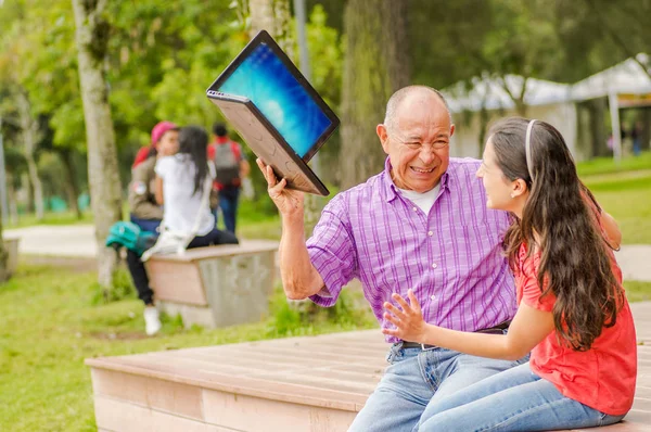 Utomhus vy av far och dotter i parken, far kommer att träffa sin dotter med datorn — Stockfoto