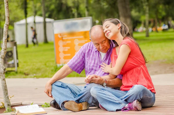 Крупним планом дочка обіймає батька з любов'ю на відкритому повітрі в парку — стокове фото