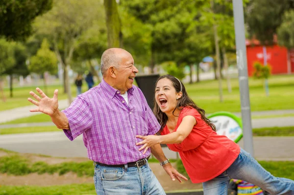 Вид снаружи на дочь и отца, играющих на улице в парке — стоковое фото