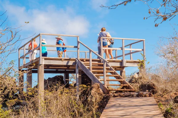 GALAPAGOS, ECUADOR, MARCH, 19 2018: Tourists walking to a hut on the Galapagos Islands surrounding of dry vegetation — Stock Photo, Image
