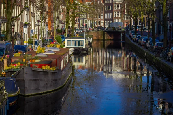 Schöne Außenansicht von Häusern und Booten am Amsterdam-Kanal mit gefrorenem Fluss, morgendliches Foto von farbigen Häusern im holländischen Stil mit Reflexion im Wasser — Stockfoto