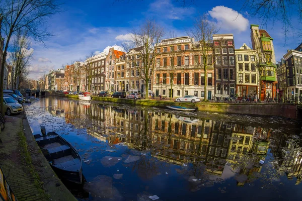 AMSTERDAM, PAESI BASSI, 10 MARZO 2018: Vista esterna di case e barche sul canale di Amsterdam. Foto mattutina di case colorate in stile olandese con riflesso in acqua — Foto Stock