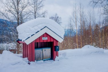 Valdres, Norveç-Mart 26, 2018: Norveç 'te kış döneminde Valdres bölgesinde ahşap bir kulübe altında açık havada iki ahşap çöp toplayıcıları açık görünüm
