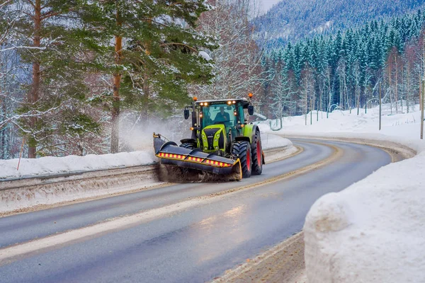 Valdres, Noruega - 26 de marzo de 2018: Vista al aire libre de la máquina quitanieves limpia la calle de la carretera de la nieve en la mañana árboles cubiertos de nieve y carreteras en Noruega —  Fotos de Stock