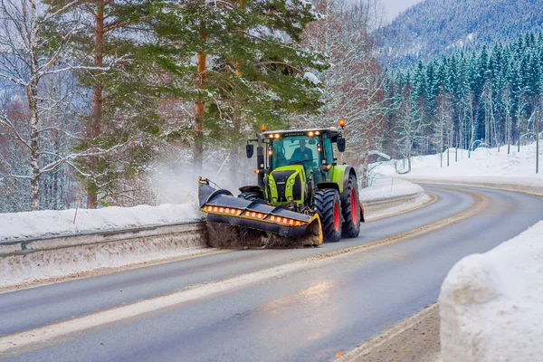 Valdres, Noruega - 26 de marzo de 2018: Vista al aire libre de la máquina quitanieves limpia la calle de la carretera de la nieve en la mañana árboles cubiertos de nieve y carreteras en Noruega —  Fotos de Stock