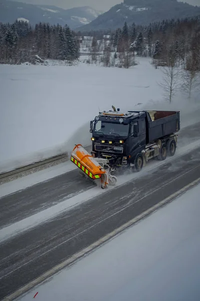 Валдрес, Норвегия - 26 марта 2018 года: Над видом снегоуборочной машины очищает улицу от снега утром заснеженных деревьев и дорог в Норвегии — стоковое фото