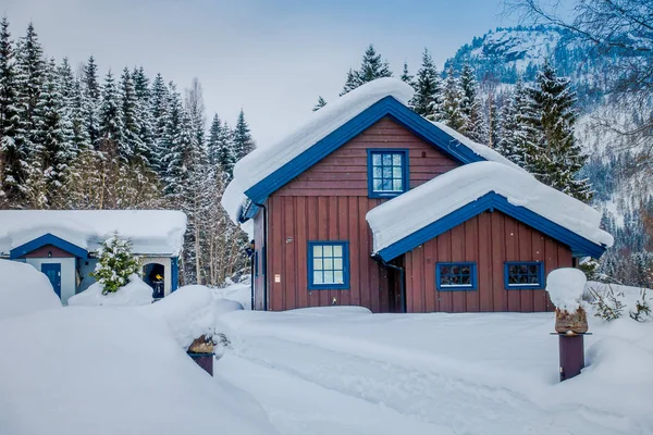 Vista de casas de madeira tradicionais cobertas de neve em deslumbrante fundo da natureza na Noruega — Fotografia de Stock