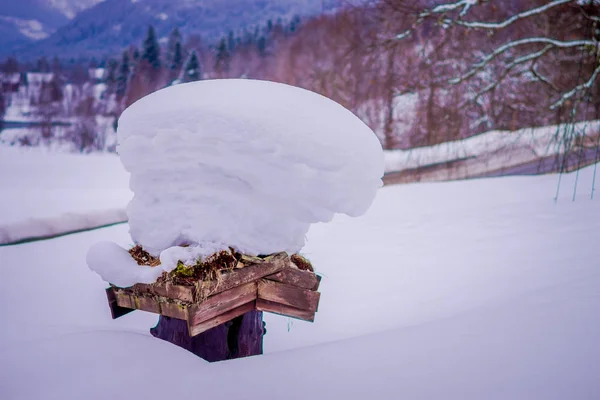 ノルウェーの道路の片側に雪で覆われたいくつかの木製の箱を持つ冬の道路の雪と氷のビュー — ストック写真