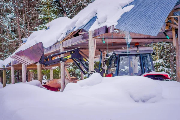 Valdres, Noruega - 26 de marzo de 2018: Vista al aire libre de un pequeño camión bajo una choza de madera que protege de la nieve pesada en Noruega —  Fotos de Stock