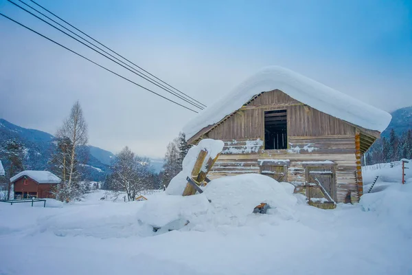 Вид снаружи традиционных домов из дерева, покрытых снегом, на потрясающую природу Норвегии — стоковое фото