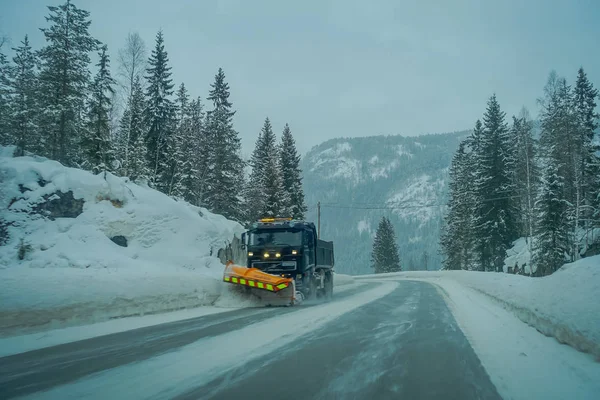 Reinli, Noruega - 26 de marzo de 2018: Vista al aire libre de la máquina quitanieves limpia la calle de la carretera de la nieve en la mañana árboles cubiertos de nieve y carreteras en Noruega —  Fotos de Stock