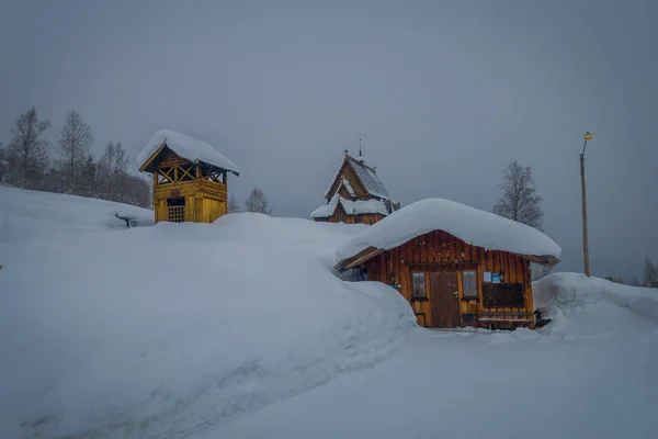 Schöne Außenansicht vieler Holzhäuser von lomen in Valdres Region, im Winter in Norwegen mit Schnee bedeckt — Stockfoto