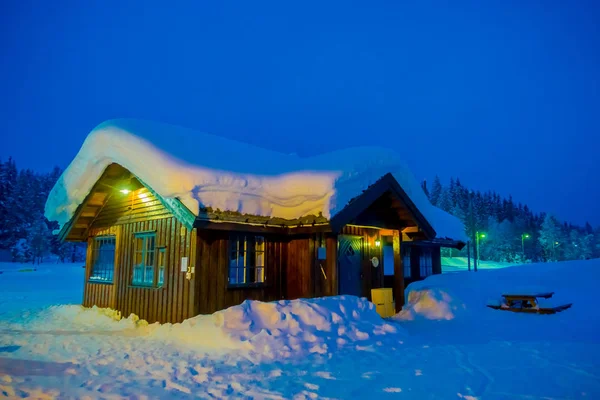 Increíble vista nocturna de casas tradicionales de madera con nieve en el techo en impresionante fondo natural en la región de Valdres en Noruega — Foto de Stock