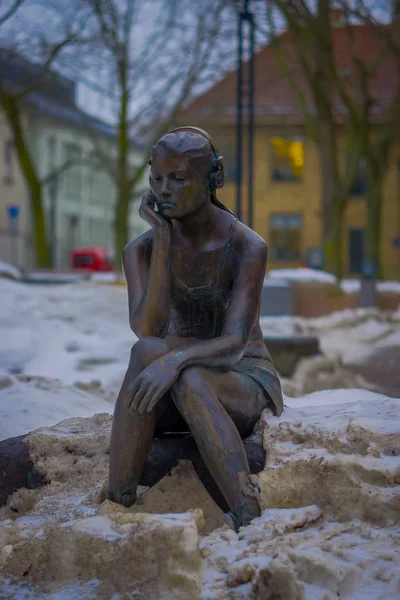 OSLO, NORWAY - MARCH, 26, 2018: Outdoor view of seated girl with headphones statue in the streets of Oslo — Stock Photo, Image