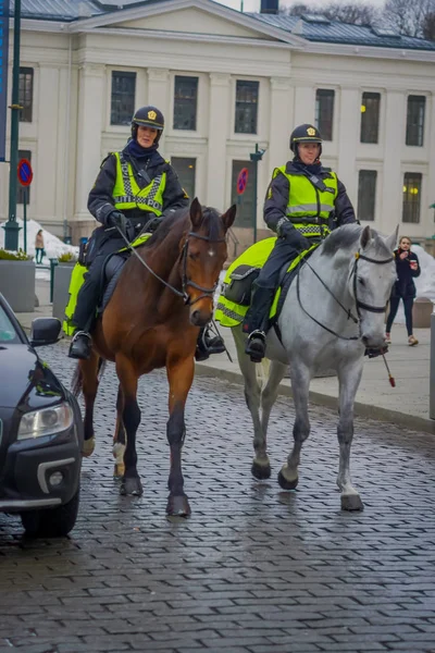 Oslo, Norwegia - 26 marca 2018 r.: Odkryty widok policji na koniu w Oslo city, blisko niezidentyfikowanych ludzi chodzących w sreets — Zdjęcie stockowe